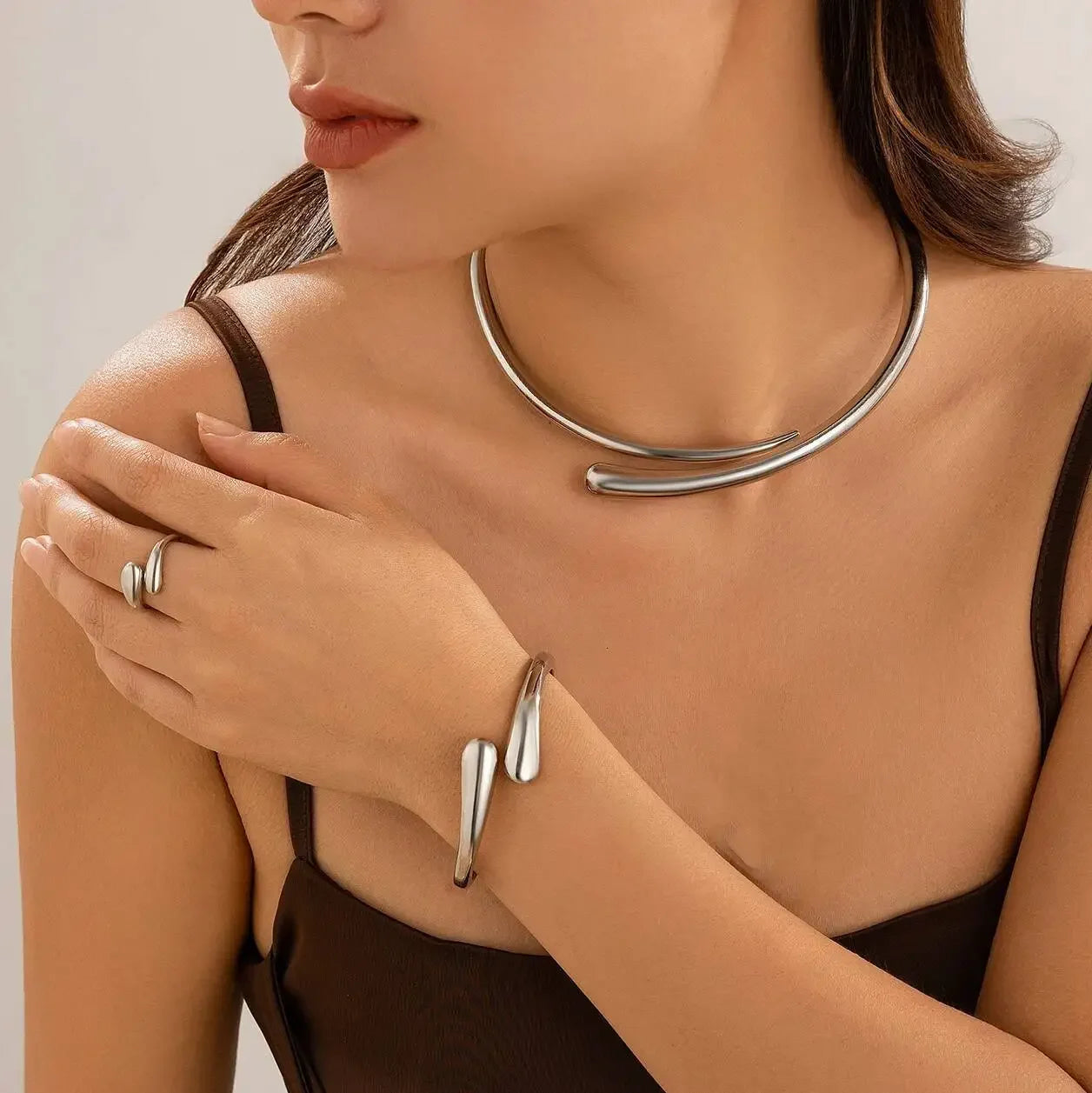 Elegant kvinde iført moderne sølvsmykker, halskæde, armbånd og ring, stilfulde accessories
