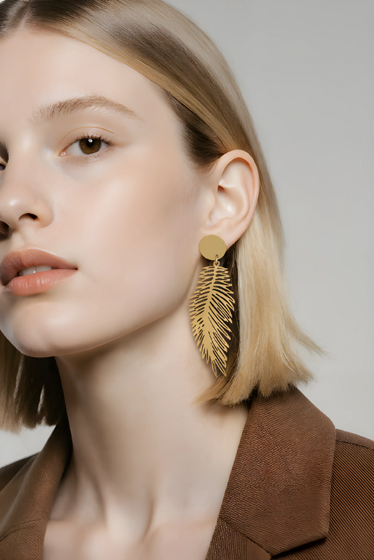 Kvinde med stort, gyldent fjer-ørering, moderne accessories, stilfuldt smykke