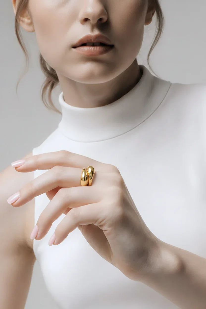 Elegant kvinde med stor gylden ring, smykkeaccessory, moderne stil, hvid baggrund