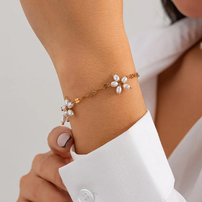 Boho perle armbånd 'Meadow' med guldfarvet blomsterdesign og imitationsperler. Elegant smykke til kvinder i boheme-stil fra Stylisk.