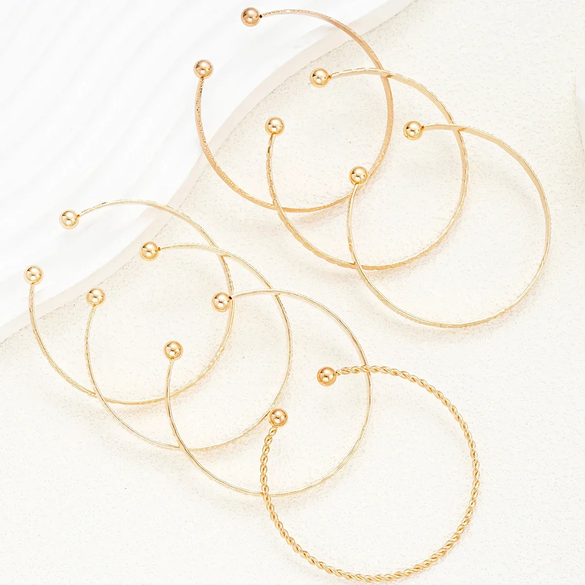 Moderne guld creoler øreringe med minimalistisk design på lys baggrund, smykker accessories