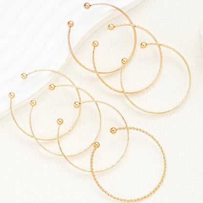 Moderne guld creoler øreringe med minimalistisk design på lys baggrund, smykker accessories