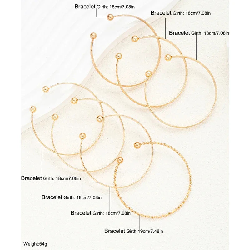 Seks elegante guldfarvede armbånd i forskellige designs og størrelser, perfekt som accessories.