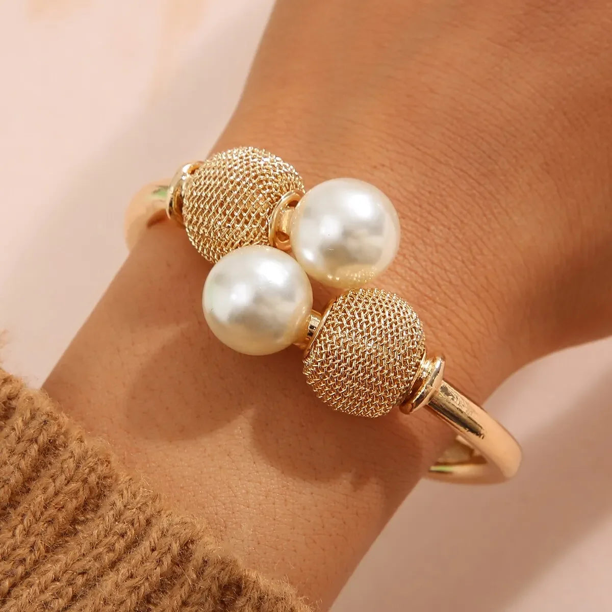 Elegant guldfarvet armbånd med perler og mesh-detaljer, moderne smykke til kvinder