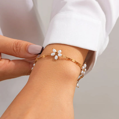 Boho perle armbånd med guldfarvet blomsterdesign og imitationsperler fra Stylisk. Elegant smykke til kvinder i boheme-stil.