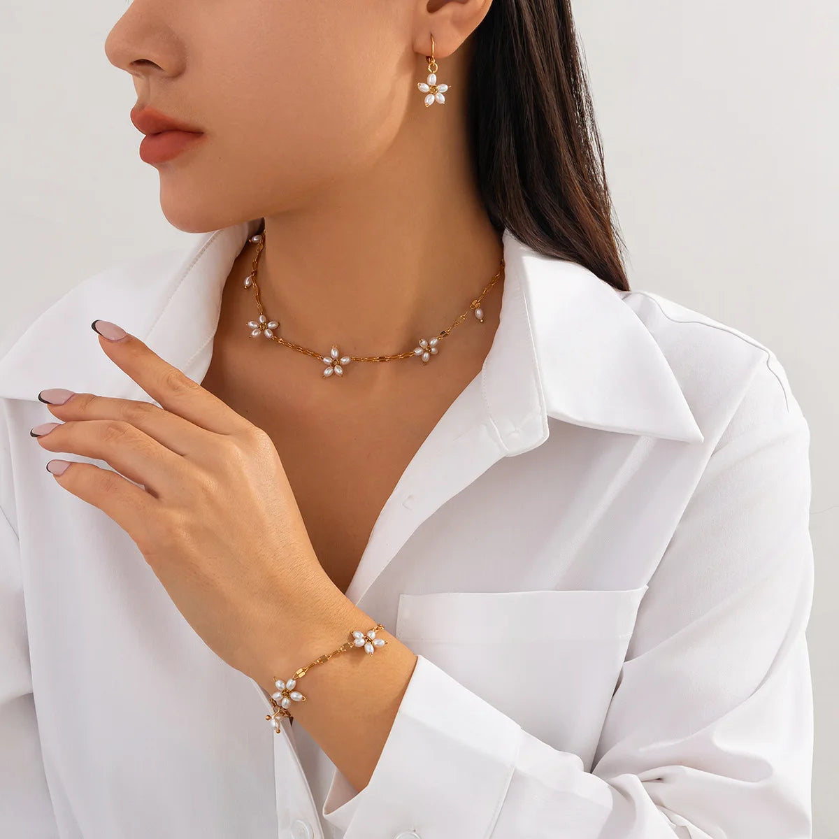 Boho perle armbånd med guldfarvet blomsterdesign og imitationsperler, stylet med matchende halskæde og øreringe. Perfekt til boheme-look.