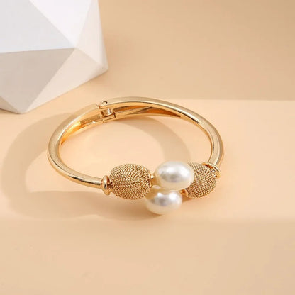 Elegant guld armbånd med perler og teksturerede kugler, moderne smykke til kvinder